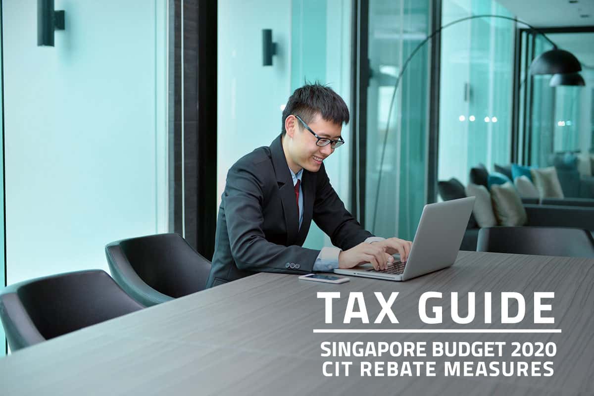 Words Tax Guide Singapore Budget 2020 Corporate Income Tax (CIT) Rebate Measures over background of an Asian man working on a laptop in an office meeting room