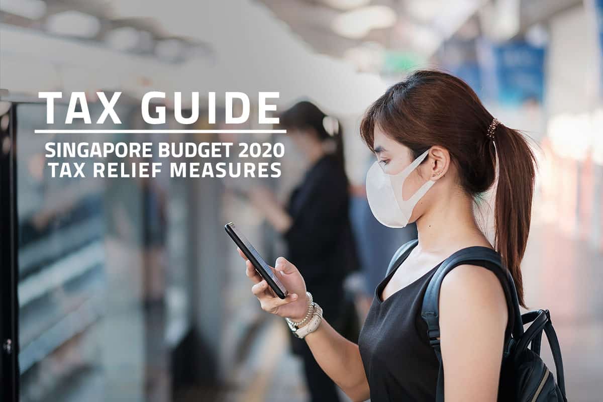 Words: Tax Guide Singapore Budget 2020 Tax Relief Measures over background of female Singapore worker wearing a face mask, looking at her mobile phone and waiting for the MRT to arrive